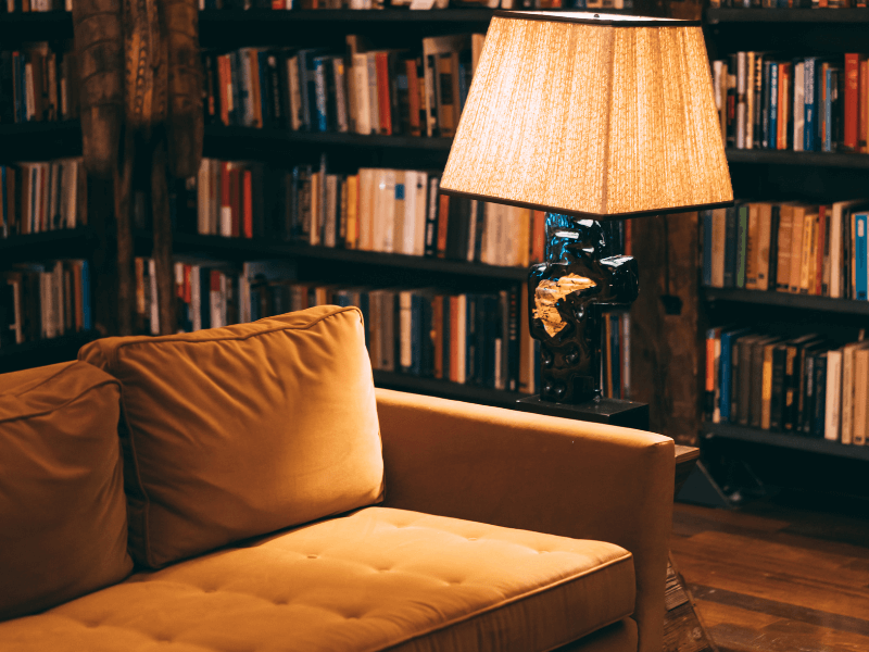 A couch and lamp in library.