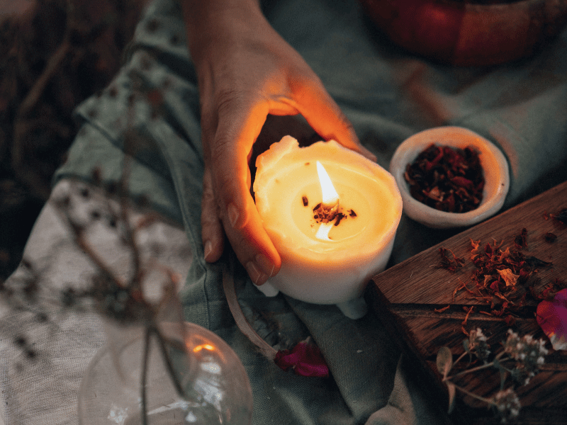 Hand holding a lit candle.